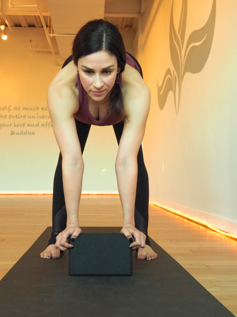 Forward fold with a block. How to modify your vinyasa yoga practice during pregnancy.