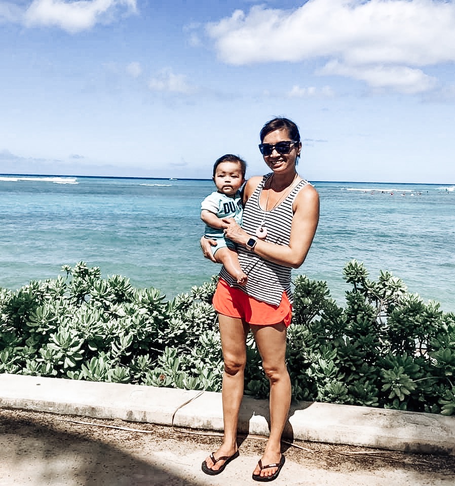 Mom in shorts and baby near water in Hawaii. Toddler Travel Tips. Lacey Hayes.
